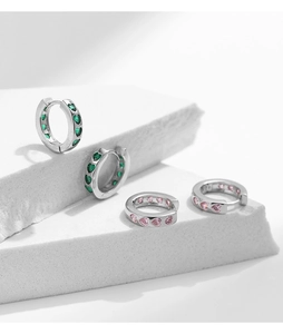 Detail of S925 silver huggie hoop earrings with pink and green heart-shaped crystals