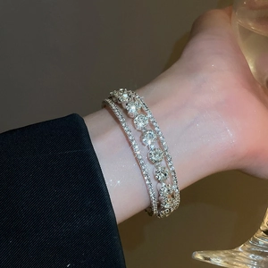 Detail of layered silver bracelet featuring sparkling zircons and fine diamond setting