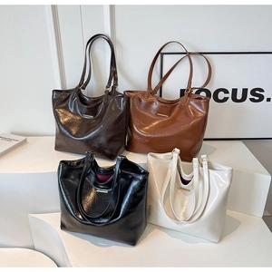 Four textured soft faux leather tote bags in brown, tan, black, and beige with metal detail