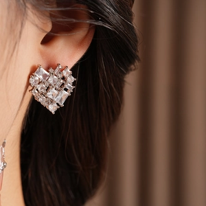 Macro shot of silver heart earrings with cubic zirconia on a model for an elegant look