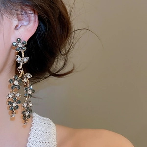 Close-up of vintage flower tassel earrings with rhinestones on a female model