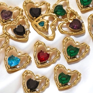 Golden heart pendants with colorful zircons in red, green and blue on white silk fabric