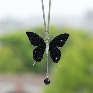 Detailed close-up of a black crystal butterfly pendant with a silver chain car ornament