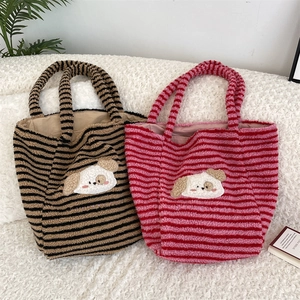 Detail of cute dog embroidery on large striped plush tote bags in autumn colors