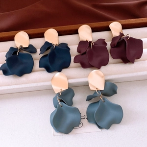 Three pairs of matte petal drop earrings in navy blue, burgundy, and grey on a jewelry tray