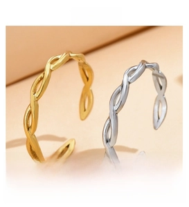 Detail of gold and silver interwoven wave pattern rings with open adjustable bands