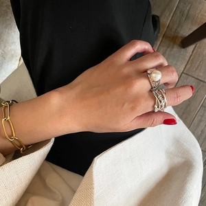 Detail showing irregular woven 925 silver rings and a large pearl ring on a model hand