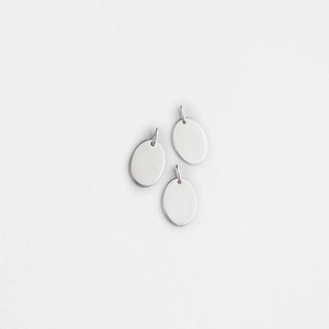 Macro shot of three oval polished stainless steel charms with jump rings for jewelry making