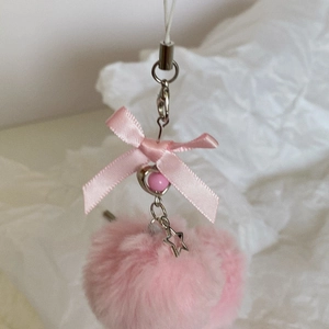 Detailed close-up of a pink plush ball charm with a satin bow and star pendant