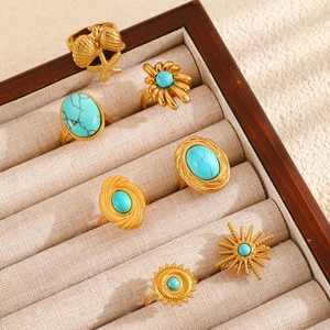 Detailed view of vintage gold rings with turquoise and nautical shell design elements