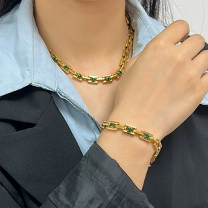 Detail view of 18K gold plated necklace and bracelet set with green emerald gemstone