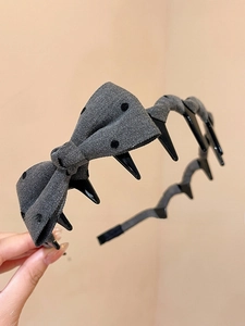 Detailed close-up of grey polka dot bow headband with non-slip inner teeth design