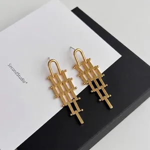Modern gold geometric tassel earrings featuring layered rectangular bar matrix design