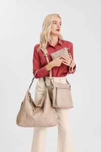 Three-piece beige tote bag set shown on model featuring shoulder, crossbody, and clutch bags