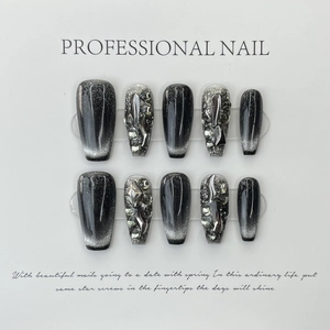 Detailed view of handmade black cat-eye press-on nails with 3D silver accents