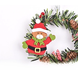 Detail of Christmas wreath with green pine needles, red berries and a cute plush bear doll