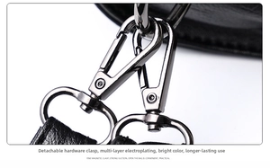 Detailaufnahme von stabilen Karabinerverschlüssen an schwarzem Leder-Handtaschenriemen