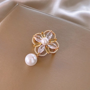 Detail of 14k gold plated flower brooch with drop pearl and marquise crystals