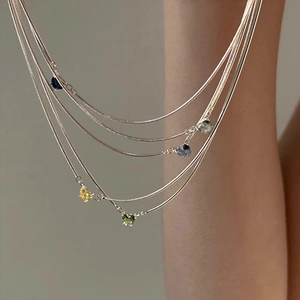 Silver layered snake chain necklace with colorful heart-shaped zircon pendants on a model