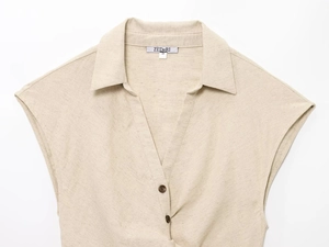 Dettaglio macro della camicia in misto lino con scollo a V, bottoni e etichetta marca