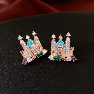 Macro shot of 18K gold plated castle earrings with colorful crystals on black texture