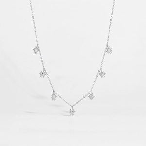 Detail of silver S925 necklace with seven sunburst charms on a delicate polished chain