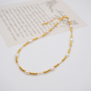 French vintage freshwater pearl necklace with gold-plated tubes on a white background