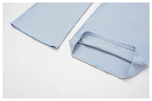 Detailed close-up of flat-lock stitching and premium texture on light blue flared yoga pants