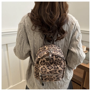 Détails du sac à dos léopard avec des lanières en cuir et des coutures blanches contrastées