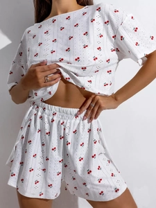 Detail der weißen Loungewear aus Lochstickerei mit süßem rotem Kirsch-Print-Muster