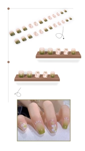 Detail of green gradient press-on nails with camellia floral patterns and pearl accents