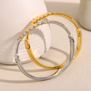 Close-up of gold and silver minimalist bangles with leaf-shaped zirconia inlays