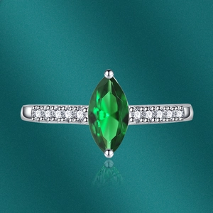 Detailed view of marquise-cut green gemstone ring with side-set zircon on silver band