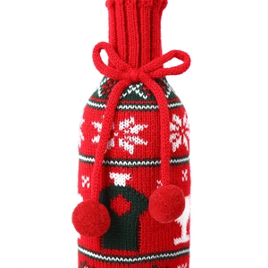 Detail of red Christmas wine bottle cover with white snowflakes and green stripes