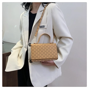Detail of light brown crossbody bag with letter print and adjustable shoulder strap