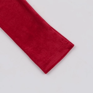 Detail shot of the velvet sleeve cuff and fine stitching on a dark red elegant dress