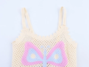 Close-up of beige crochet knit top featuring intricate mesh and colorful butterfly embroidery