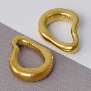Detailed close-up of two organic irregular gold pendants in 304 stainless steel material