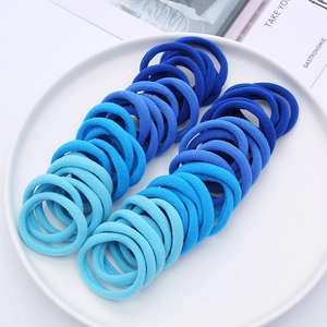 Detailed view of blue gradient seamless elastic hair ties arranged in a round white tray