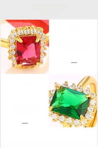 Macro shot of luxurious gold plated rings with emerald and ruby cut gemstones and clear zircons