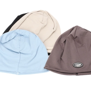 Detail view of four multi-color knitted beanies with fashion leather label decoration