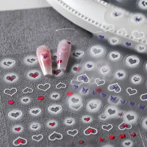 Detail of 3D nail art stickers with red and purple heart and butterfly designs