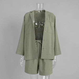 Detail of sage green textured cotton-linen shirt with large pockets and drawstring shorts