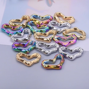 Macro view of textured heart-shaped pendants in gold, silver and rainbow finishes