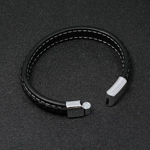Detailed close-up of a black braided leather bracelet with a silver magnetic clasp