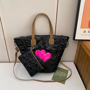 Detail der schwarzen Stepptasche aus Nylon mit pinkem Herz und passender kleiner Tasche