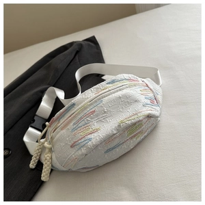 Detail of white embossed crossbody bag with rainbow embroidery and textured strap