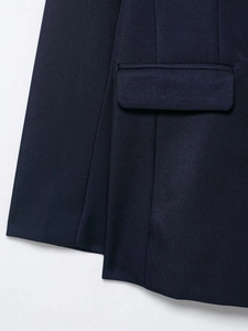 Detail of navy blue blazer featuring twill fabric texture and pocket flap stitching