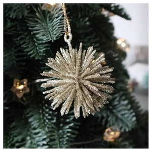 Close-up of champagne gold glitter star ornament hanging on a lush green Christmas tree