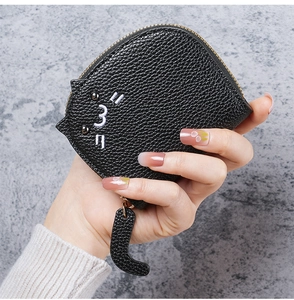 Close-up of black cat card holder in lychee grain leather with unique tail zipper pull